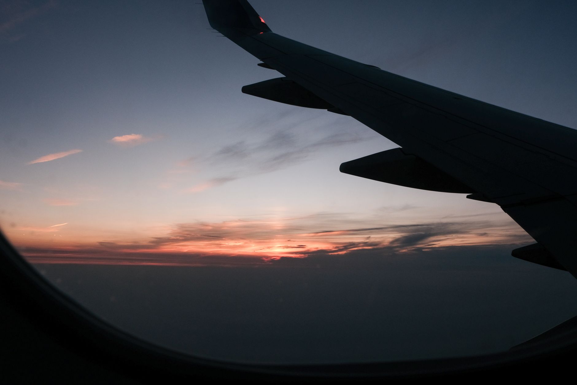 Airplane wing with a breathtaking sunset seen through the window, ideal for travel themes.